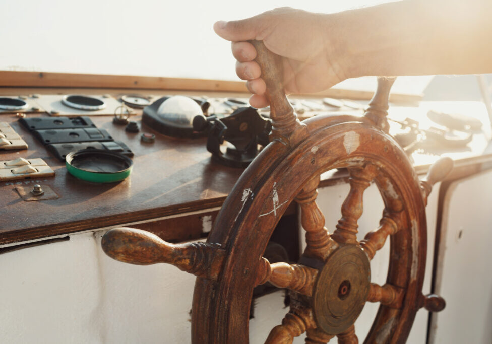 Sun shines over the wooden wheel held by man